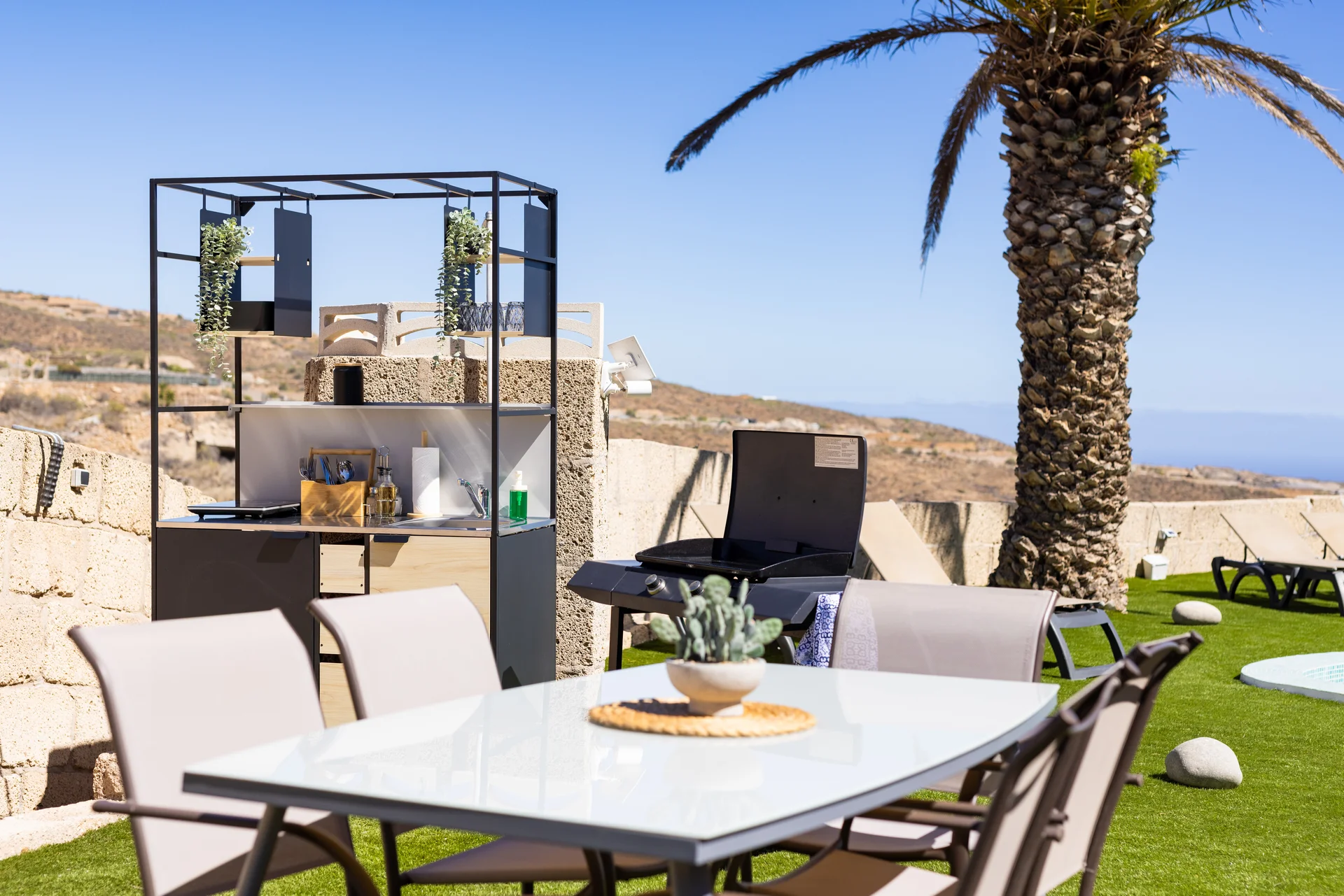 Fully equipped outdoor kitchen with dining tables at Oasis Tenerife Rentals